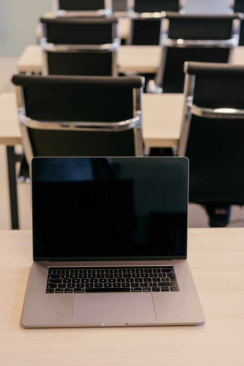 Free An empty conference room setup with a laptop on a desk, ready for a seminar. Stock Photo