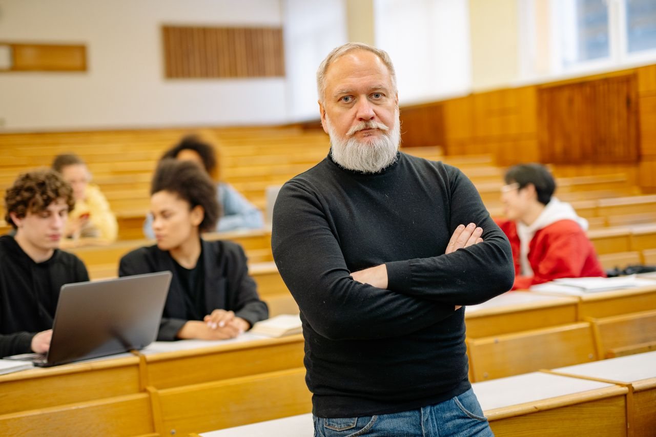 Free Confident professor in lecture hall with diverse students engaged in learning. Stock Photo