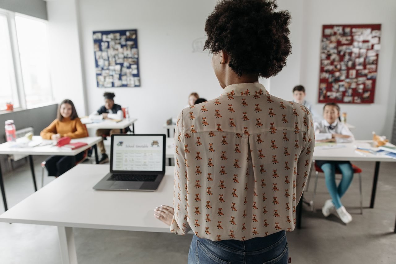 Free Female teacher engaging students in a classroom setting with diverse learners. Stock Photo