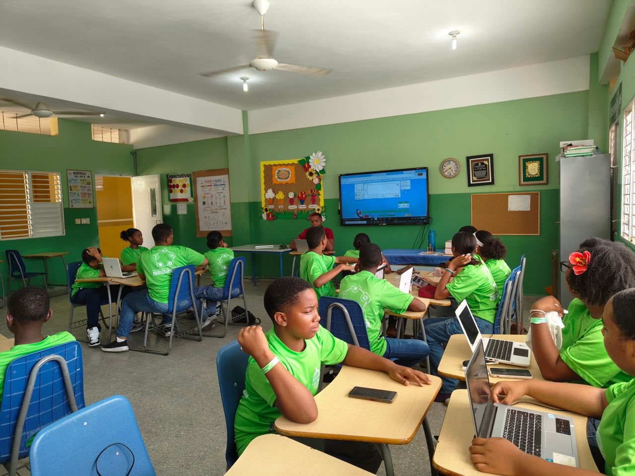 Free Group of students in a classroom using laptops and participating in a lesson. Stock Photo